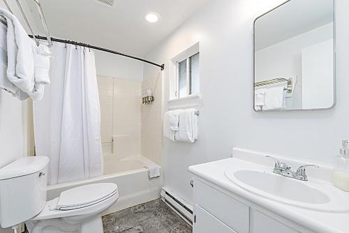 Baño blanco con aseo y lavamanos en Tidal House 9, en Ocean Shores