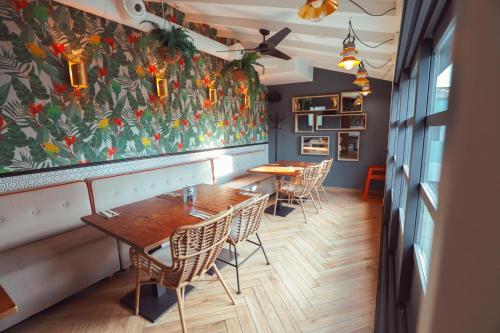 a restaurant with tables and chairs and a floral wall at MYR Marqués House in Valencia