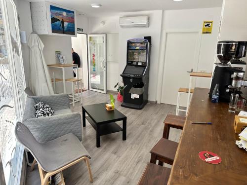 uma sala de estar com um sofá e um jogo de vídeo em Be Happy Hostel em Nerja