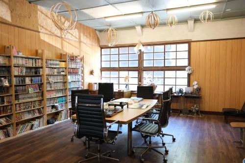 a library with a table and chairs in it at 奈良吉野の小学校跡地ゲストハウス-五右衛門風呂体験-漫画図書室-卓球台-一棟貸し-素泊まり-吉野山天川村観光-Small inn attached to a historic school building in Zengi