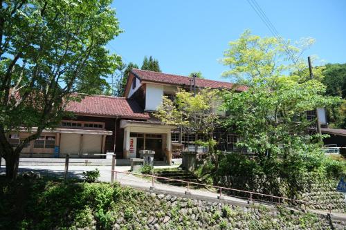 a house with a fence in front of it at 奈良吉野の小学校跡地ゲストハウス-五右衛門風呂体験-漫画図書室-卓球台-一棟貸し-素泊まり-吉野山天川村観光-Small inn attached to a historic school building in Zengi