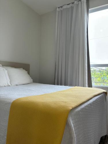 a bedroom with a bed with a yellow blanket on it at HOTEL PORTO in Valença