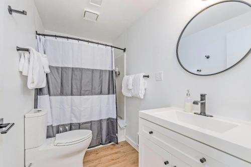 Baño blanco con lavabo y espejo en Tidal House 3, en Ocean Shores