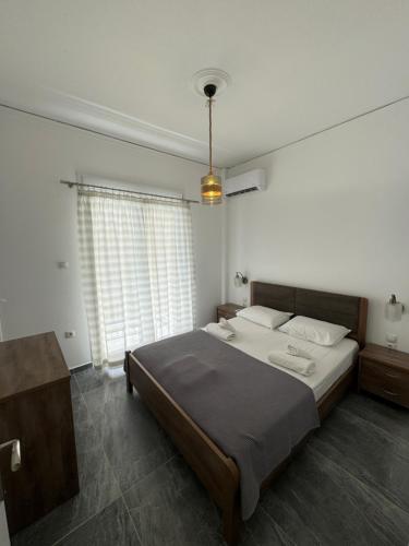 a bedroom with a large bed and a large window at Mano’s House Preveza in Preveza