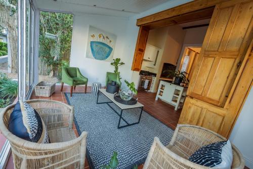 a living room with wicker chairs and a table at Bonne Esperance Boutique Guest House in Stellenbosch