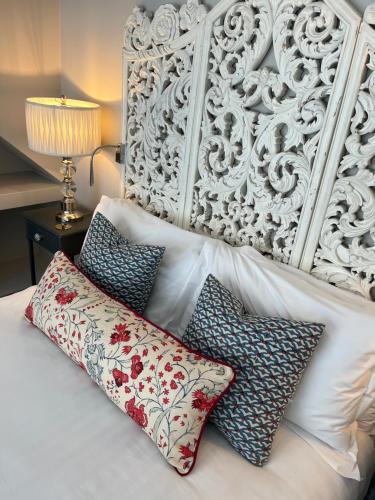 a white bed with pillows on top of it at Rooms at number one in Broadstairs