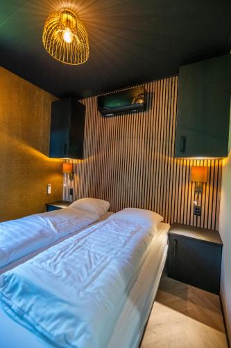a bedroom with a large bed and two night stands at Wellnesslodge Specht jacuzzi and sauna and privacy in Dalerveen