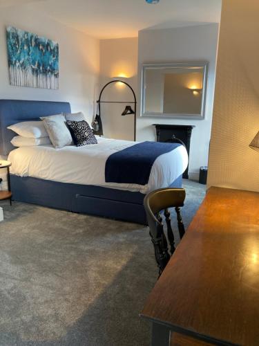 a bedroom with a bed and a table and a desk at Crick Cottage Rooms in Crick