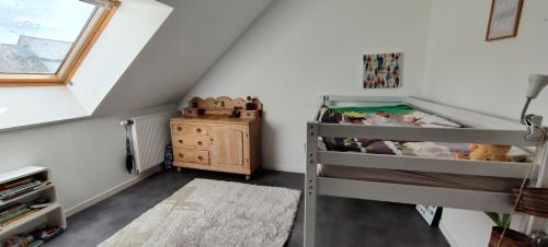 - une chambre pour enfants avec des lits superposés et une fenêtre dans l'établissement Maison de vacances à 5 min des plages, à Ploemeur