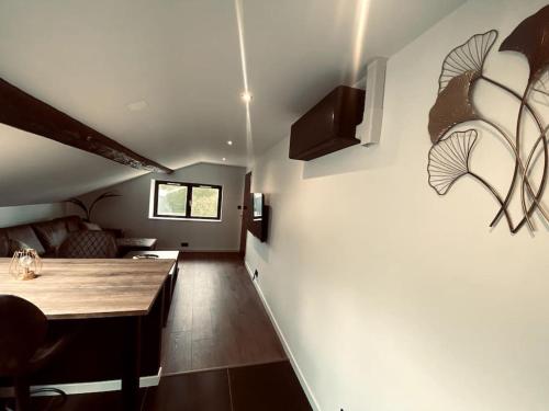 une cuisine et un salon avec une table au mur dans l'établissement Appartement 1000 et une nuits, à Saint-Avold