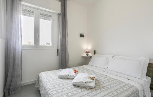 Un dormitorio con una cama con toallas y una ventana. en Amazing Home In Santa Maria Del Focall, en Santa Maria del Focallo