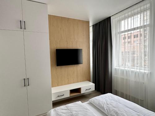 una camera da letto con un letto e una TV a parete di 118 apartments a Kiev