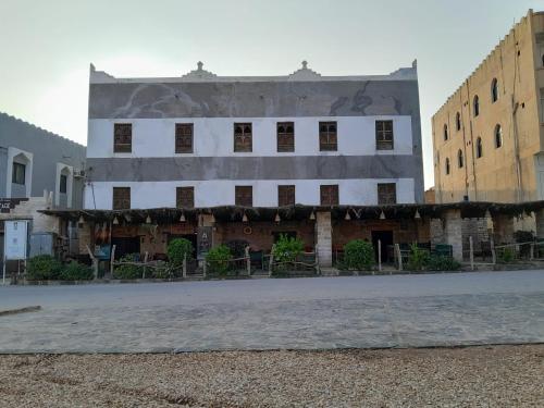 un viejo edificio en medio de una calle en نزل كوفان التراثي Koofan Heritage Lodge en Salalah