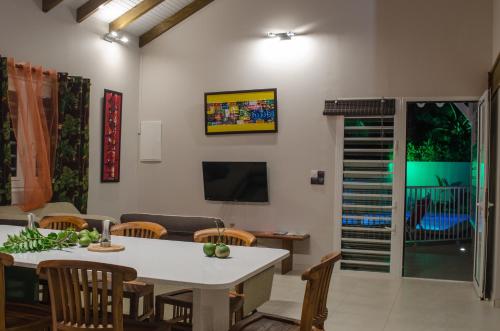 a dining room with a white table and chairs at Residence Can' Hibiscus in Le Marin