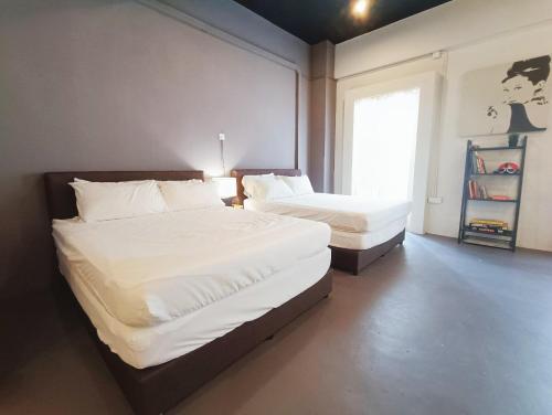 a bedroom with two beds and a window at Melaka Riviera Studio 15 in Melaka