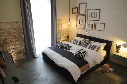 Un dormitorio con una cama grande con almohadas. en Shurhuq Ospitalità Siciliana, en Avola
