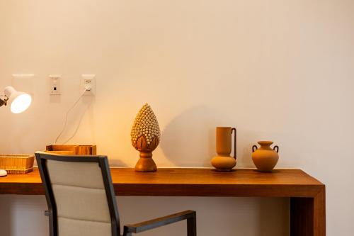 a wooden table with vases on top of it at Aldeia Jericoacoara - Suites Privativas in Jericoacoara