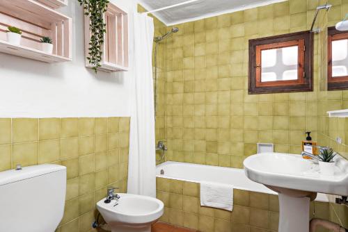 a bathroom with a toilet and a sink and a tub at Bini Luna - Binibeca Vell in Binibeca