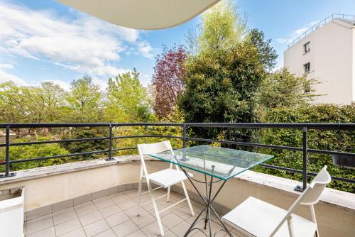 d'un balcon avec une table et des chaises en verre. dans l'établissement GuestReady - Era uma vez em Montparnasse, à Paris