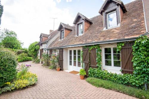 a house with a brick driveway in front of it at La Maison aux Mille Fleurs in Mosnes