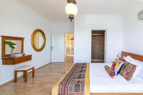 a bedroom with a bed and a mirror and a table at Sofia Ada in Fethiye
