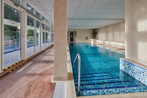 a large swimming pool in a building with a swimming poolvisorvisor at Fermain Valley Hotel in St Peter Port