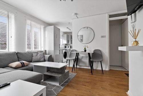 a living room with a couch and a table at Shades of white in Mill Hill in Hendon