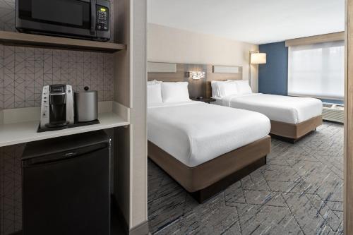 a hotel room with two beds and a tv at Holiday Inn Express Hotel & Suites Freeport by IHG in Freeport