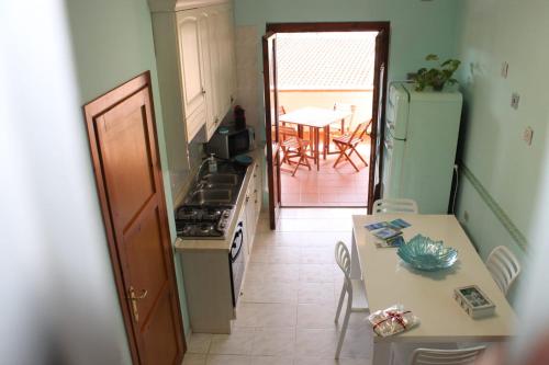 a kitchen with a stove and a table and a dining room at La Perla nel Blu in Villasimius