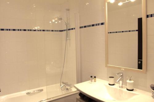 une salle de bain avec une douche, un lavabo et un miroir dans l'établissement Short Stay Paris Apartments, à Paris