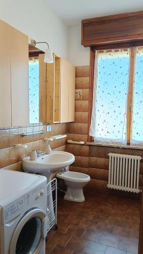 a bathroom with a washing machine and a sink at Appartamento Laura in Quargnento
