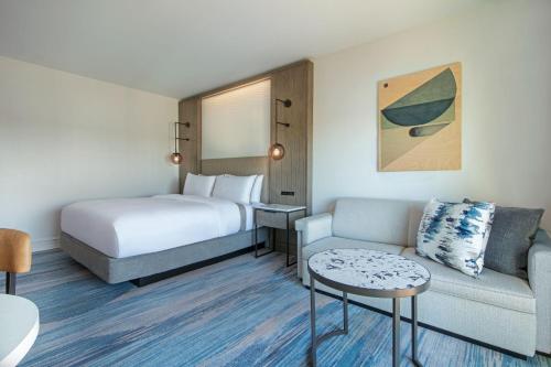 a hotel room with a bed and a couch at The Westin Sacramento Riverfront Hotel & Spa in Sacramento