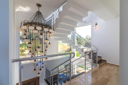 a staircase with a chandelier in a house at Sofia Ada in Fethiye