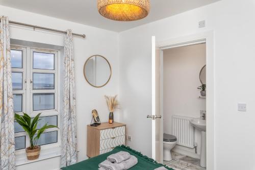 a white bathroom with a bed and a mirror at Mariners Point in Hartlepool