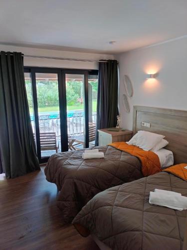 a hotel room with two beds and a balcony at Quinta Padre Lobo in Santa Maria Da Feira