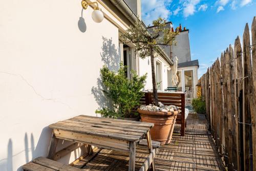 une table et un banc en bois sur le côté d'une maison dans l'établissement GuestReady - Ocean blue with Sacré-Cœur views, à Paris
