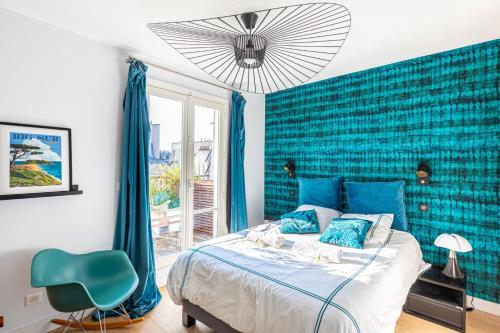 - une chambre avec un lit et un mur bleu dans l'établissement GuestReady - Ocean blue with Sacré-Cœur views, à Paris