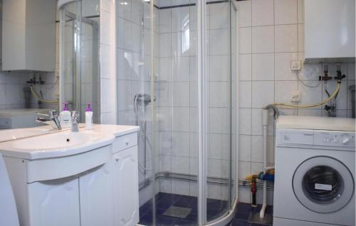 La salle de bains est pourvue d'une douche, d'un lavabo et d'un lave-linge. dans l'établissement 2 Bedroom Pet Friendly Home In Beddingestrand, à Beddinge Strand