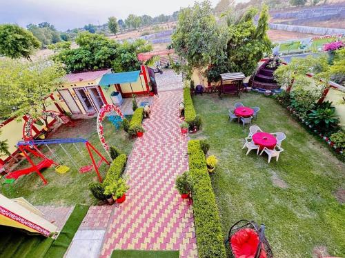 - une vue aérienne sur un jardin avec des tables et des chaises dans l'établissement Bundeli Farm Resort & Banquet Orchha, à Orchha
