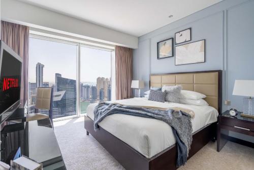 a bedroom with a large bed and a large window at GuestReady - Marina Walk View at JW Marriott in Dubai
