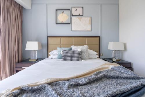 a bedroom with a large white bed with two lamps at GuestReady - Marina Walk View at JW Marriott in Dubai