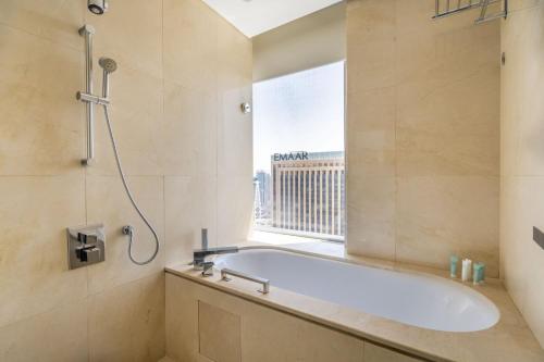 a bathroom with a bath tub and a window at GuestReady - Marina Walk View at JW Marriott in Dubai