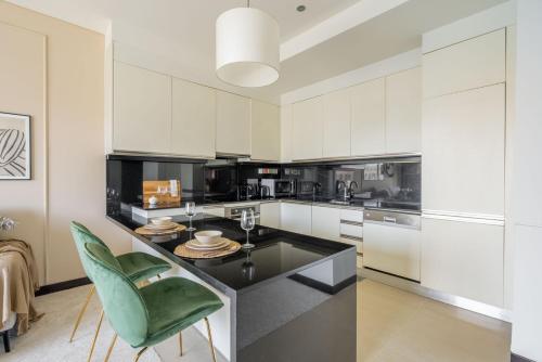 a kitchen with white cabinets and a black counter top at GuestReady - Marina Walk View at JW Marriott in Dubai