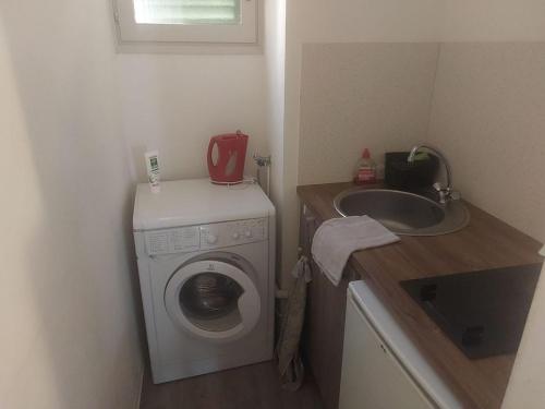 une petite salle de bains avec un lave-linge et un lavabo dans l'établissement AJACCIO Beau Studio pour 3 a 4 pers en Plein Centre de la Vieille Ville Historique, à Ajaccio