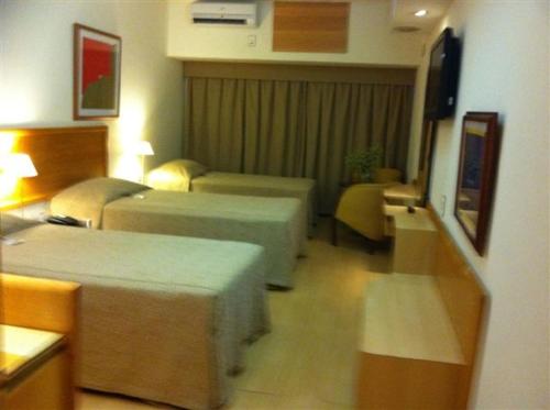 リオデジャネイロにあるサウス アメリカン コパカバーナ ホテルのベッド2台とソファが備わるホテルルームです。