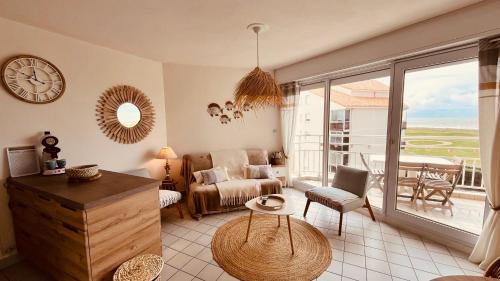- un salon avec un canapé et un réveil dans l'établissement Studio Le golf, piscine & océan, à Saint-Jean-de-Monts