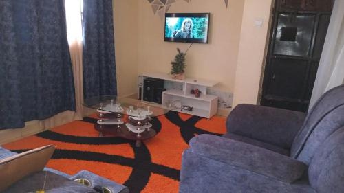 a living room with a couch and a glass table at Georgia Furnished Apartments in Machakos