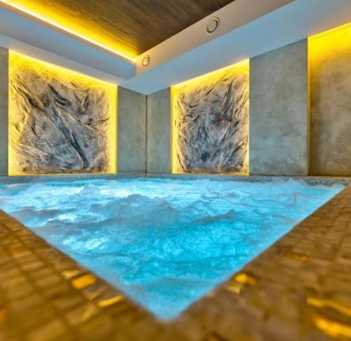 een groot zwembad met water in een kamer met rotsen bij BINIS 34 in Zlatibor