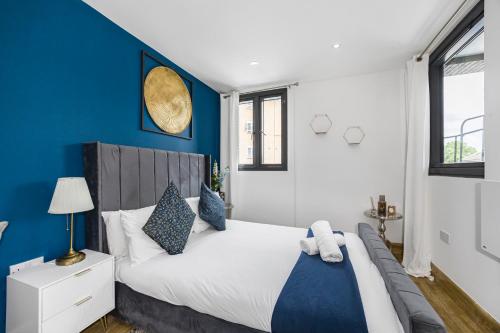 a bedroom with a large bed with blue walls at Marylebone City Apartments in London