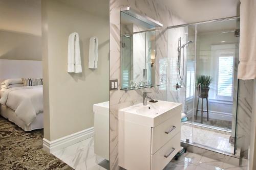 a white bathroom with a sink and a shower at Wine & Roses Hotel Restaurant Spa Lodi in Lodi